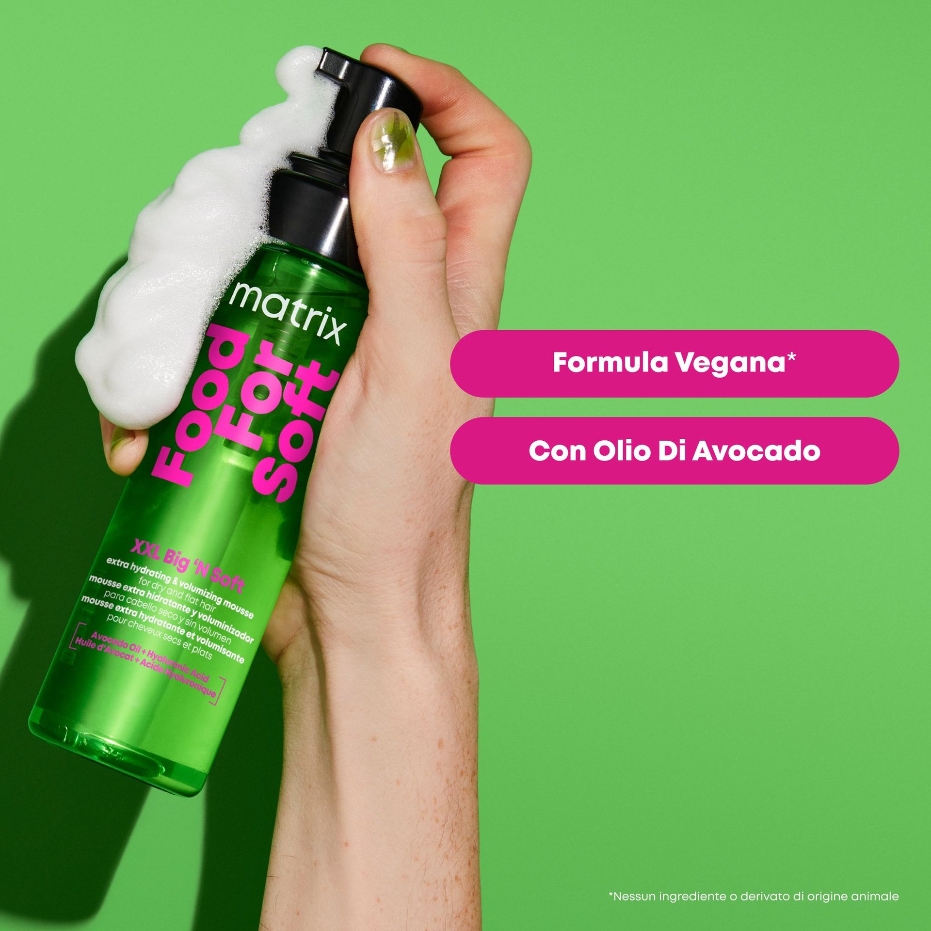 Mano che tiene la mousse Food For Soft XXL Big 'N Soft con formula vegana e avocado su sfondo verde